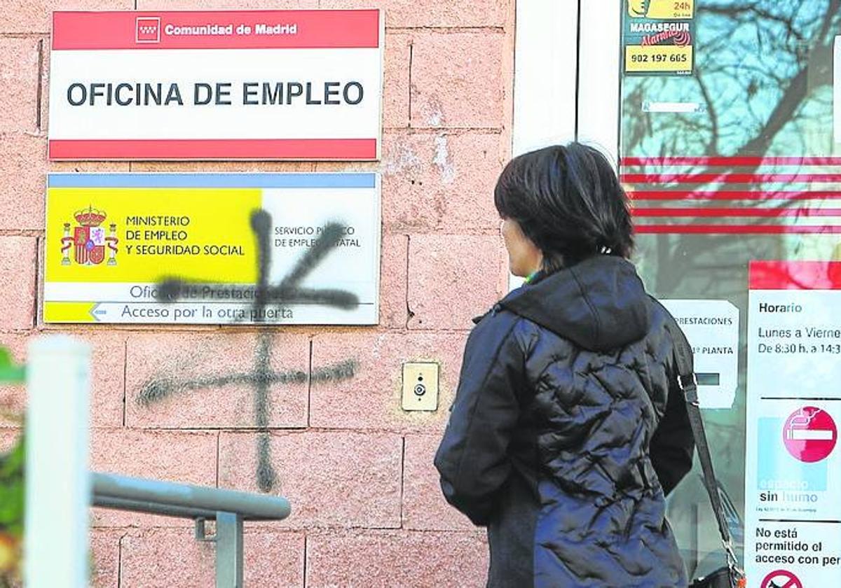 Una mujer a las puertas de una oficina de empleo.