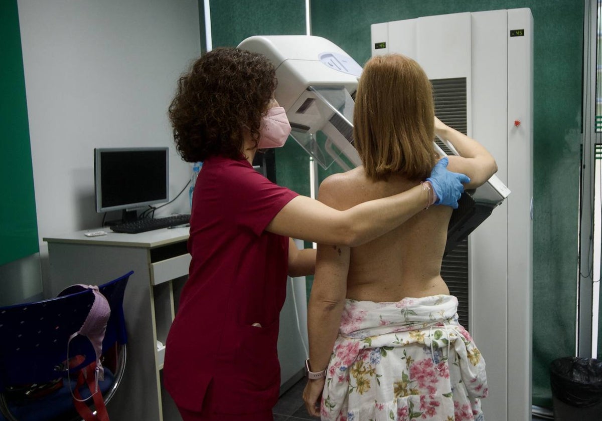 Una profesional sanitaria realiza una mamografía a una paciente.