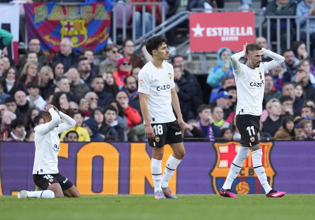 Los jugadores del Valencia lamentan una ocasión fallada durante el partido de LaLiga entre Barcelona y Valencia, este domingo en el Camp Nou.