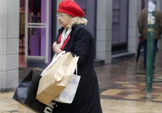 Una mujer recorre las calles de Valencia cargada de bolsas.