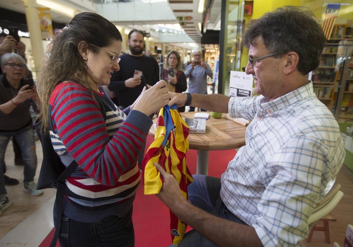 Mario Kempes firma una camiseta de la Senyera a una aficionada.