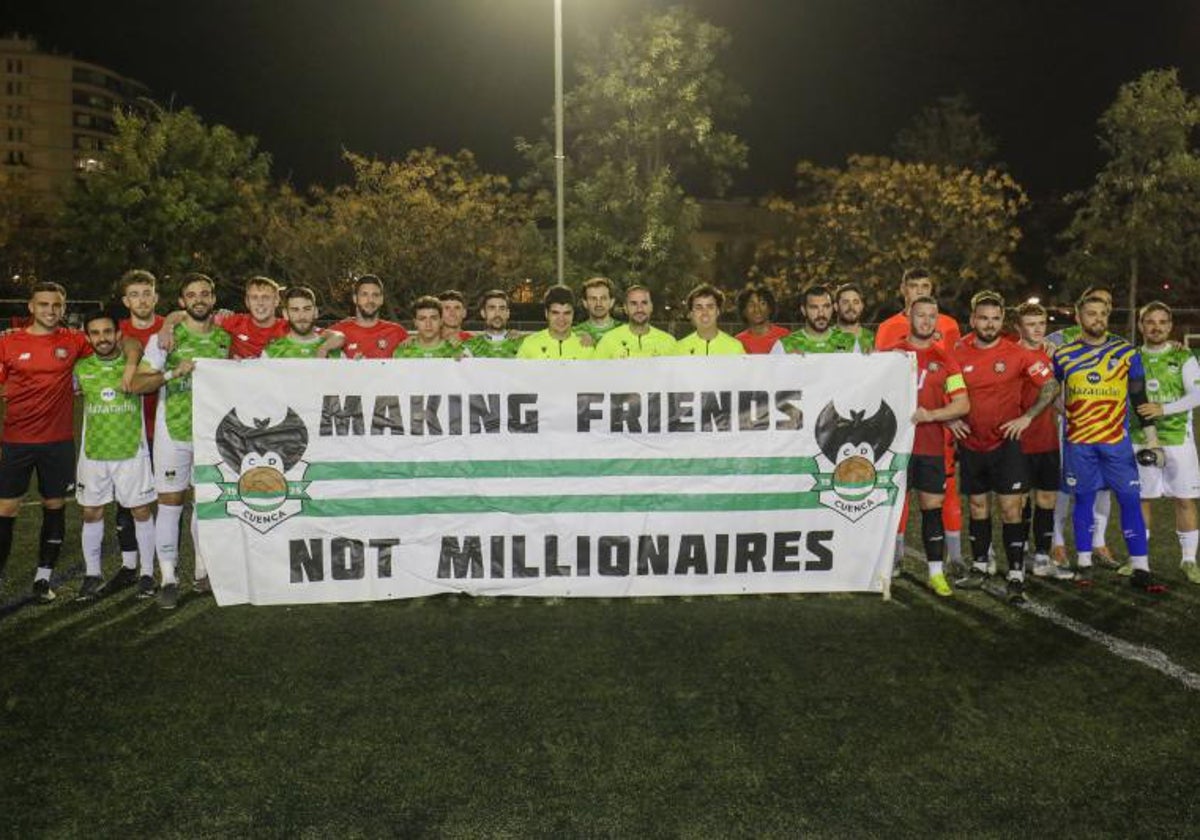 Los jugadores posando con una pancarta que pone 'Haciendo amigos. No millonarios'.