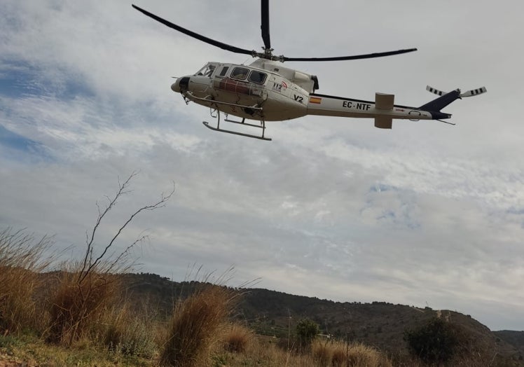 Un helicóptero sobrevuela la zona quemada en Llombai.