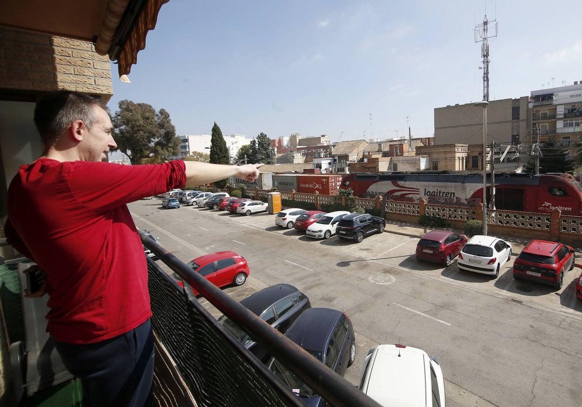 José, en el balcón de su casa mientras pasa un tren de mercancías.