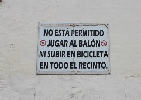 Imagen secundaria 1 - Arriba, Bego e Irenia, tras la barra del único bar abierto en Las Virtudes. Un cartel en la pared del santuario.