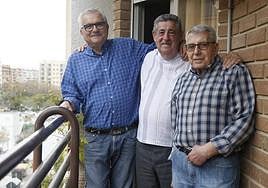 José Vicente García, Enrique Cañada y José Sáez, compañeros de piso, en el balcón de su vivienda en Valencia.