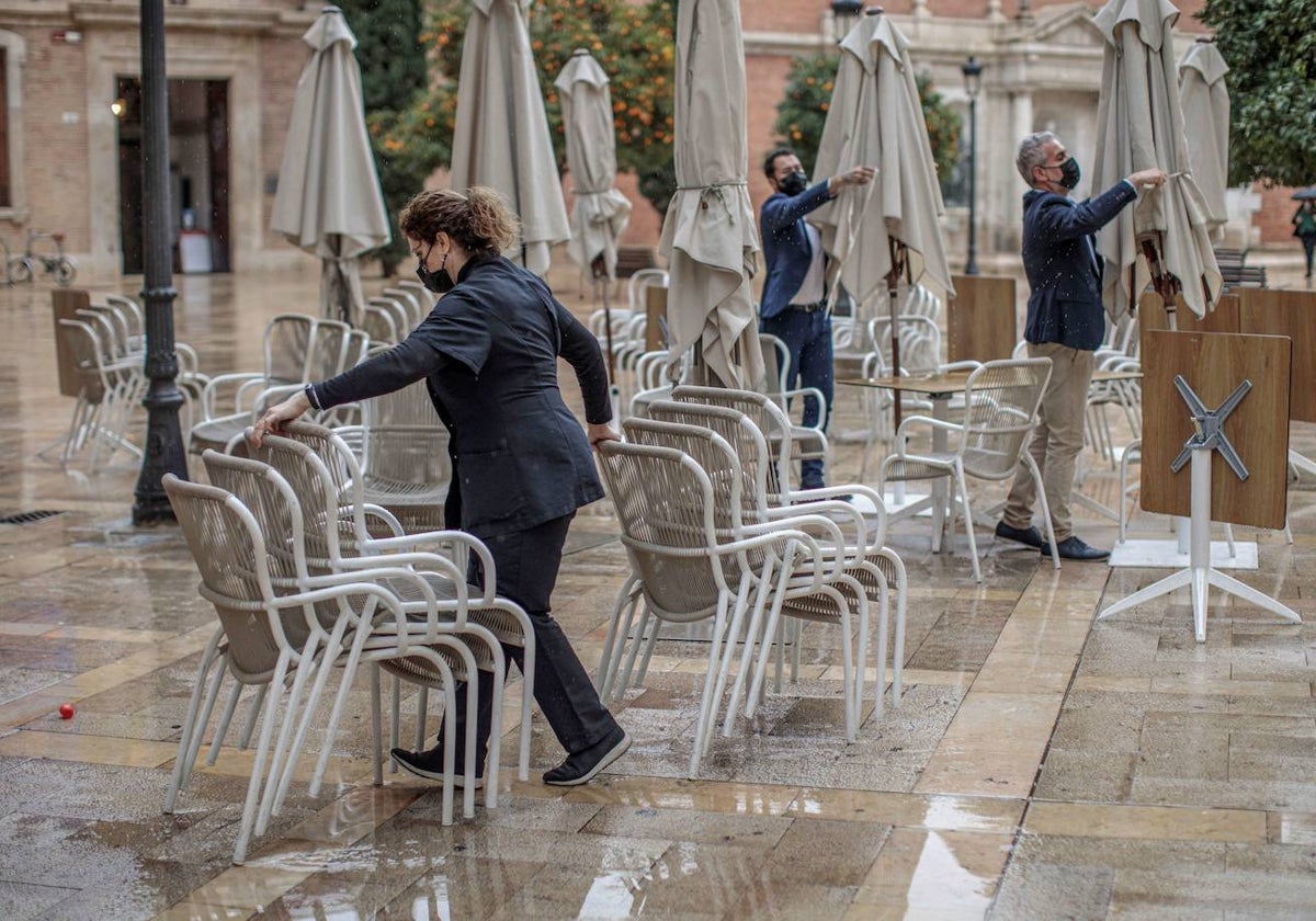 Unos trabajadores de un restaurante del centro recogen la terraza.