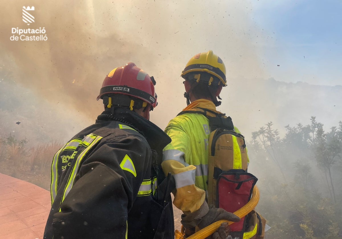 Dos bomberos luchan contra las llamas, el domingo, en el incendio de Oropesa.