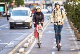 Personas en patinete eléctrico en Valencia.