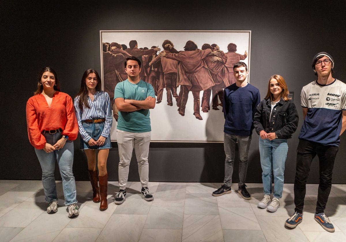 Seis jóvenes nuevos votantes posan junto a 'El abrazo' de Juan Genovés, expuesto en el Centro Cultural Bancaja.