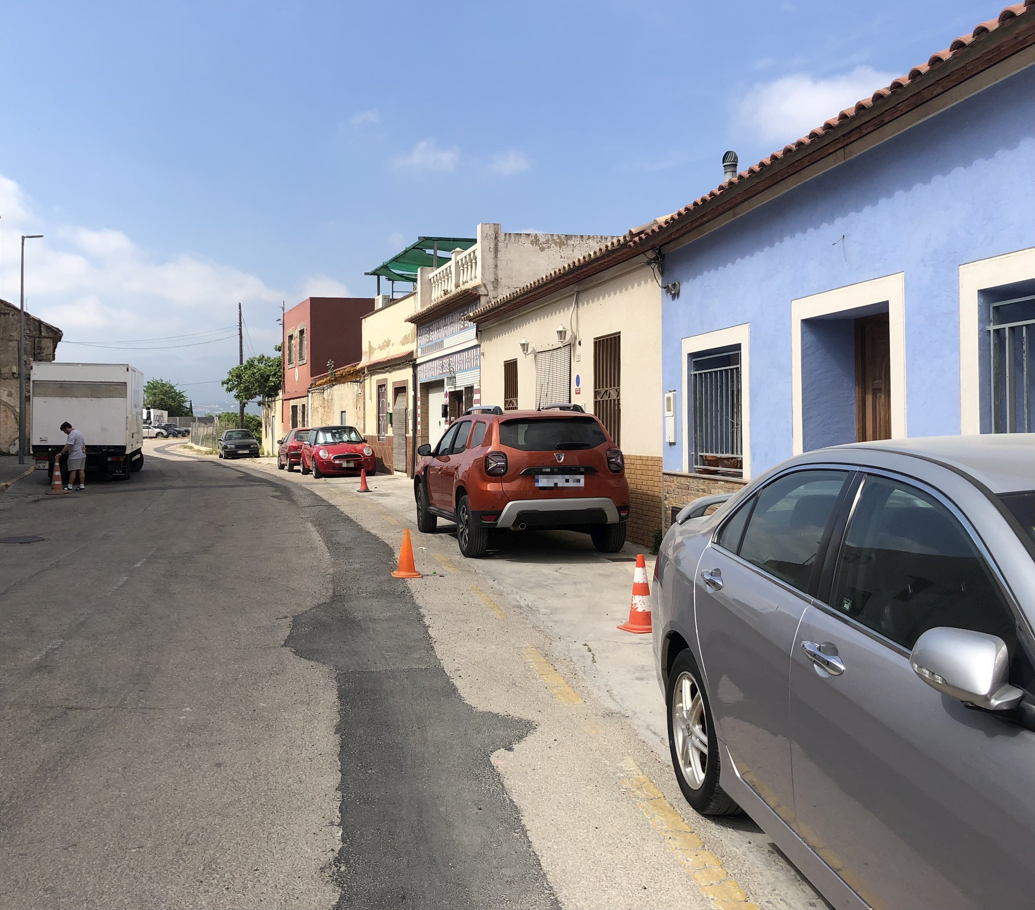 Tramo de Sant Enric donde se aprecia que no hay aceras y los vehículos aparcan junto a las viviendas.