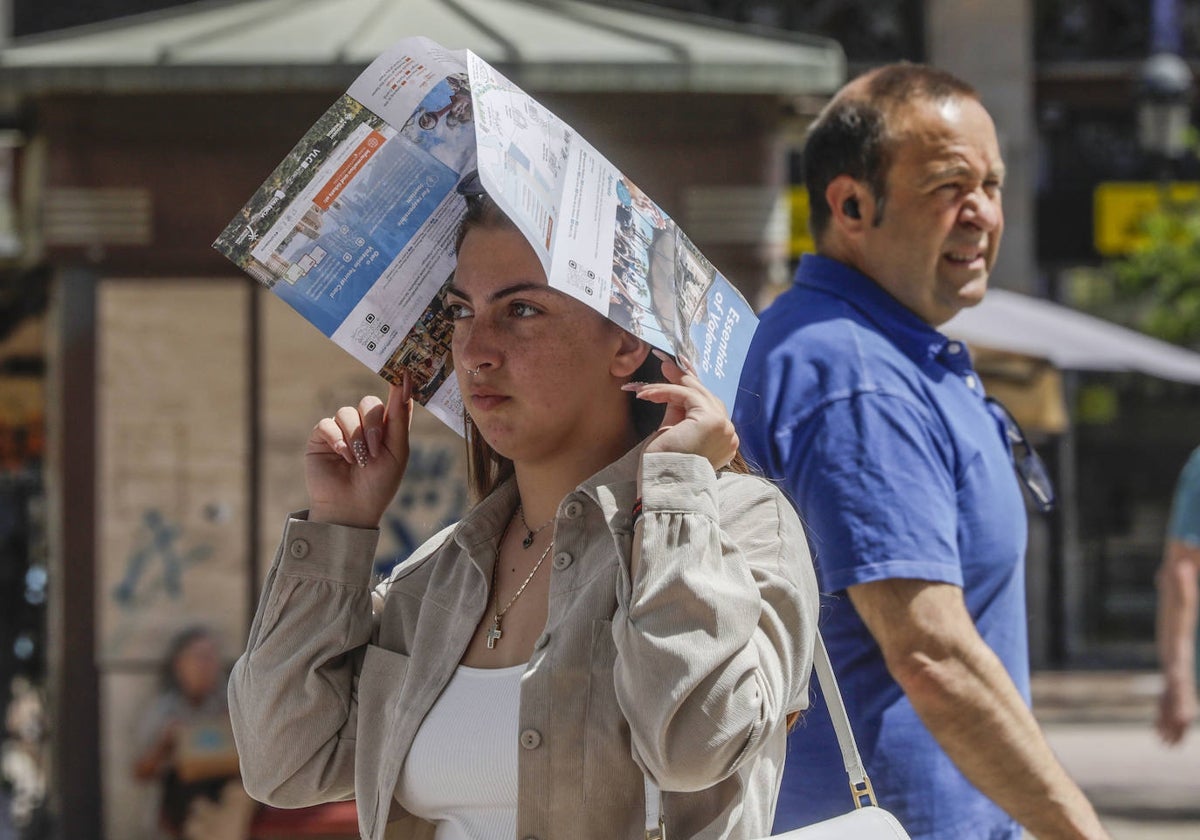 Una joven se protege del calor en Valencia.