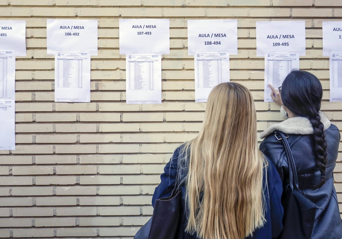 Dos estudiantes consultan la ubicación para realizar el examen que permite optar a una plaza MIR.