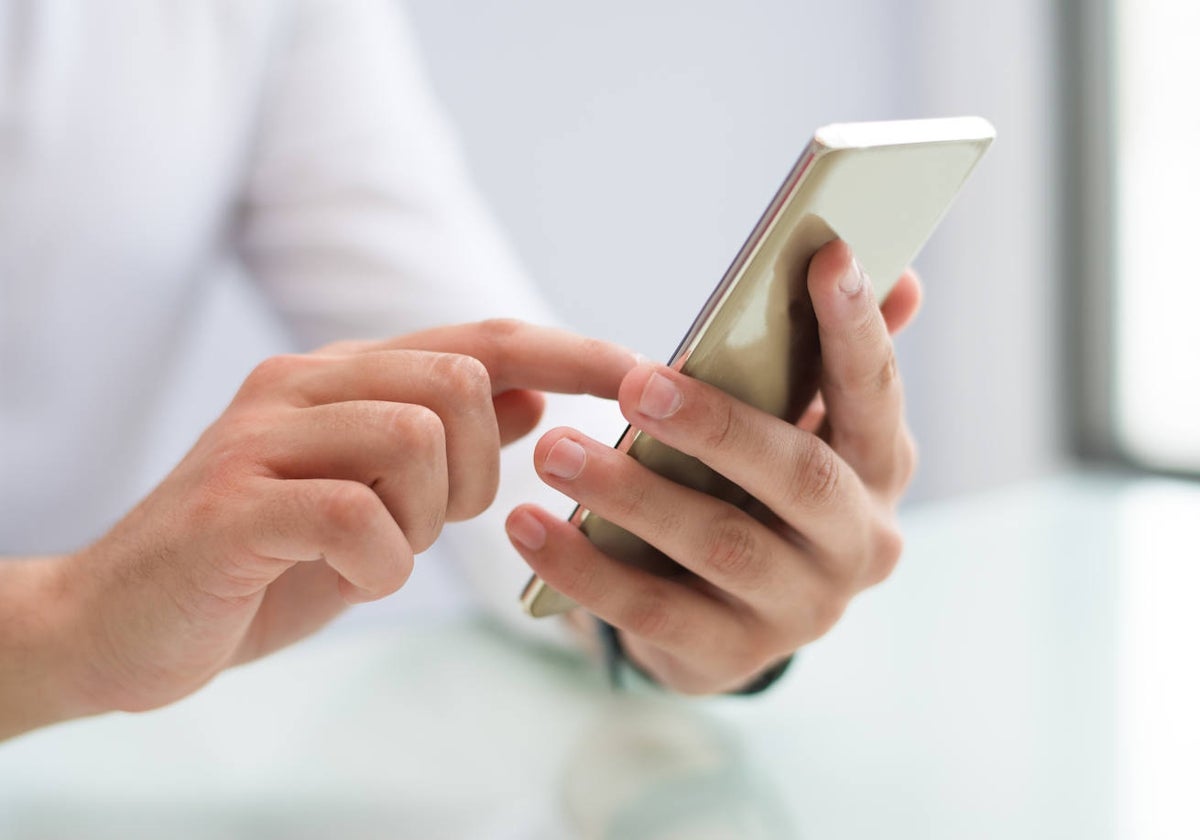 Una mujer manejando su teléfono móvil.