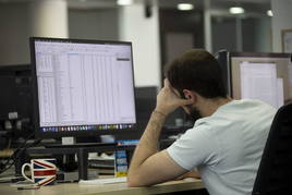 Un trabajador mira la pantalla de su ordenador en la oficina.