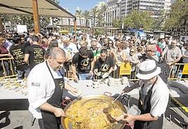 Cocineros reparten raciones de paella en la Plaza del Ayuntamiento