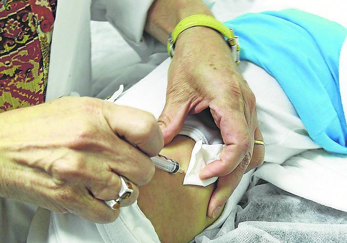 Personal sanitario administra una vacuna a un niño.