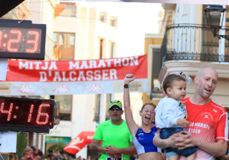 Un padre con su hijo tras llegar a la meta final.