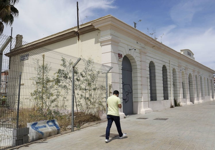 Un viandante pasa junto a la antigua estación del Grao.