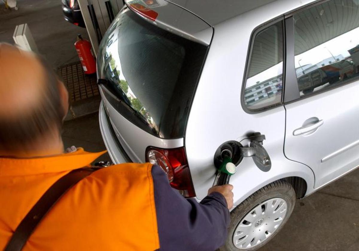 Un empleado de una gasolinera recarga combustible en un vehículo, en imagen de archivo.