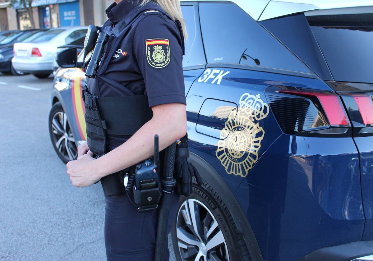 Una agente de la Policía Nacional, junto a su coche patrulla, en una imagen de archivo.