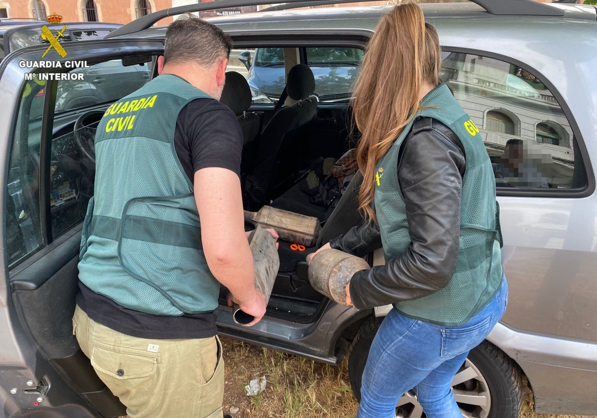 Dos agentes de la Guardia Civil introducen catalizadores en su vehículo.