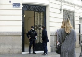 Un policía, en la puerta de la finca de la calle Conde Altea en la que se produjo el crimen.