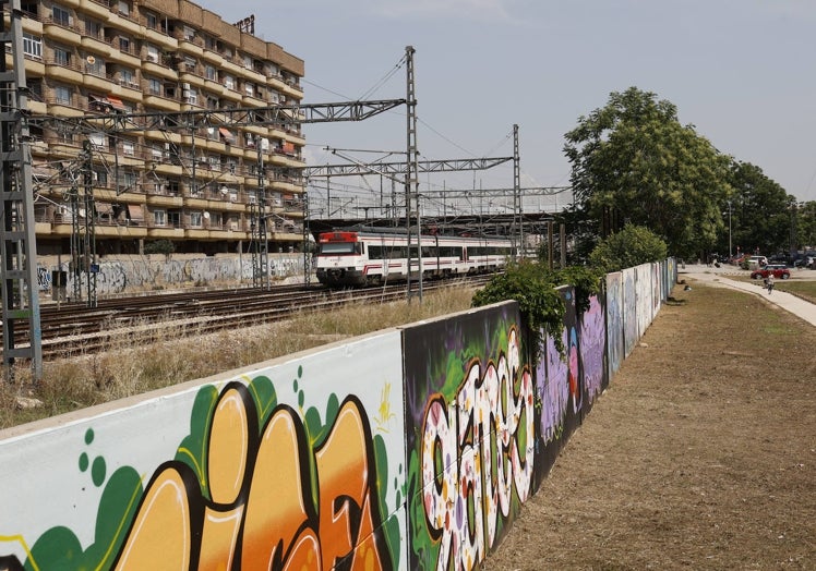 Imagen principal - Calle Oltá y el muro que separa a los vecinos del resto del barrio por las vías del tren.