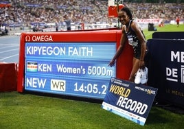 Kipyegon posa junto a la marca que estableció como nuevo récord del mundo.