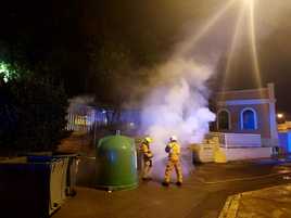 Los bomberos sofocan uno de los fuegos en un contenedor.