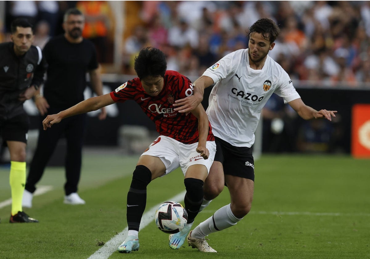 Kang In protege el balón ante la presión de Nico, en el partido de esta temporada en Mestalla.