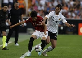 Kang In protege el balón ante la presión de Nico, en el partido de esta temporada en Mestalla.