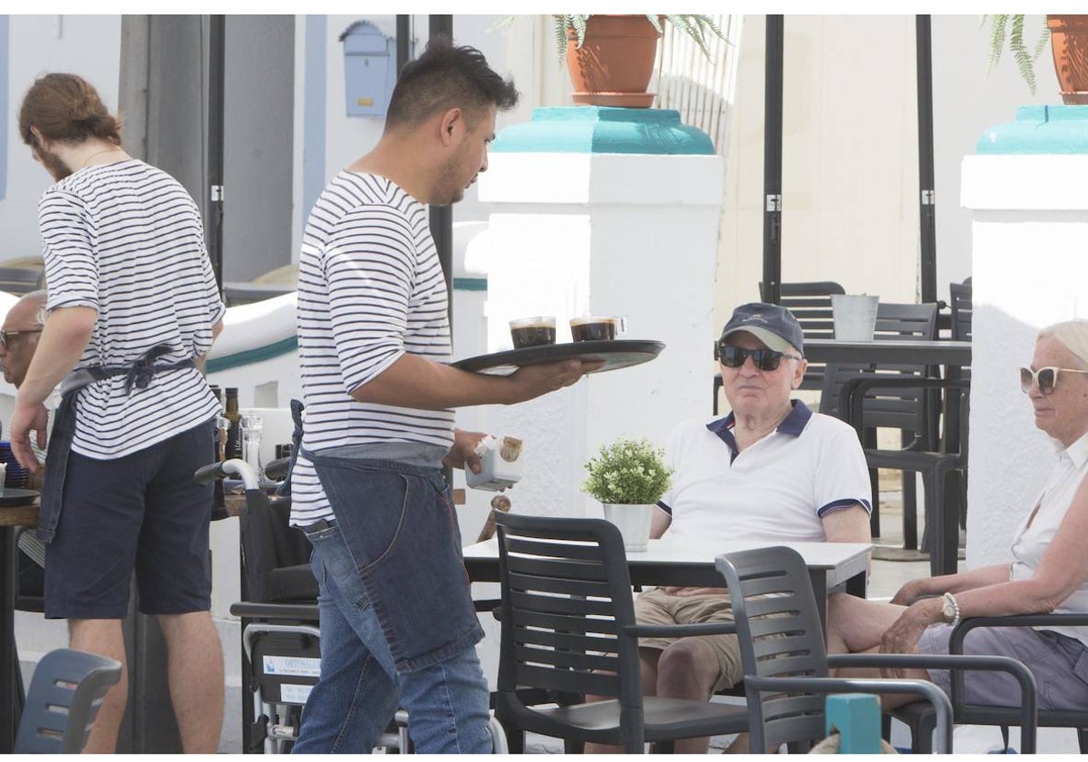 Dos camareros atienden a los clientes en un bar de Valencia.