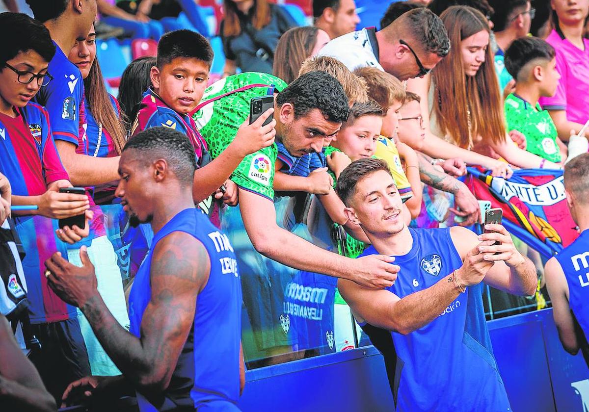 Pablo Martínez y Wesley, haciéndose fotos con aficionados del Levante en el entrenamiento abierto del Ciutat.