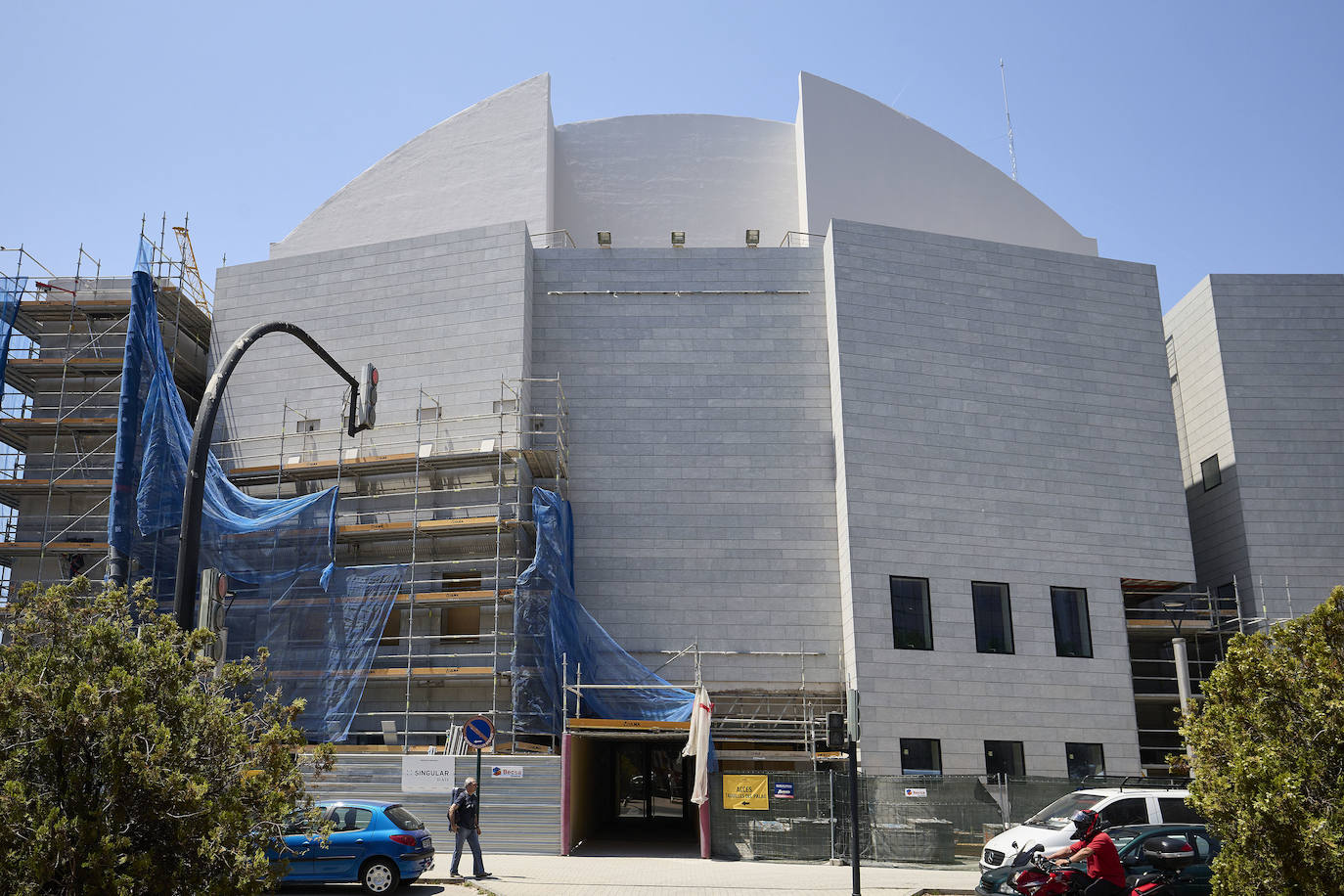 Imagen principal - En la imagen superior, la retirada del andamiaje. En la fotografía del centro, el nuevo acristalmiento del vestíbulo. En la tercera imagen, dos operarios trabajan en recuperr el jardín aledaño al Palau de la Música. 