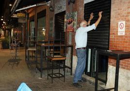 Un hombre cierra su cafetería en una imagen de archivo.