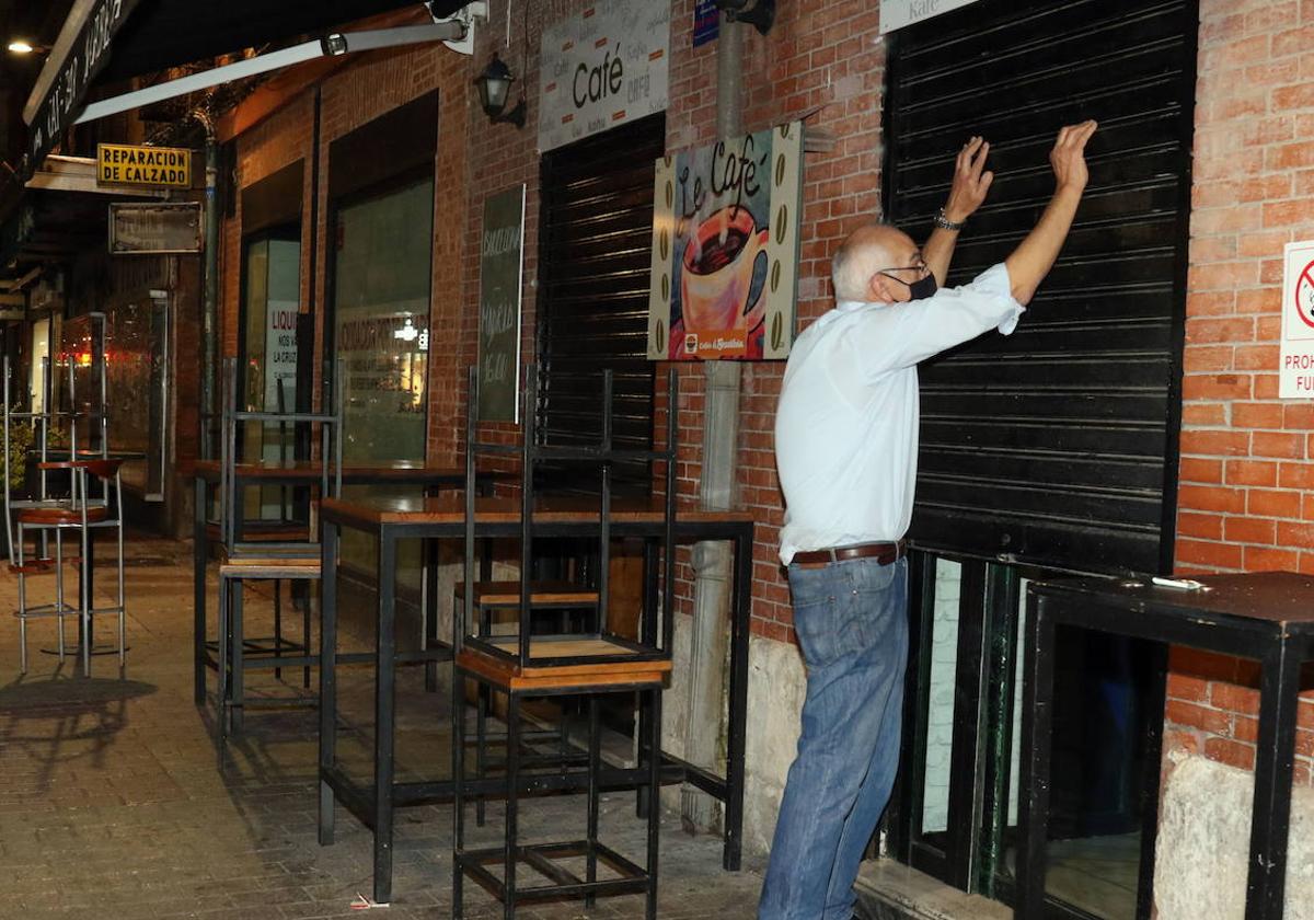 Un hombre cierra su cafetería en una imagen de archivo.