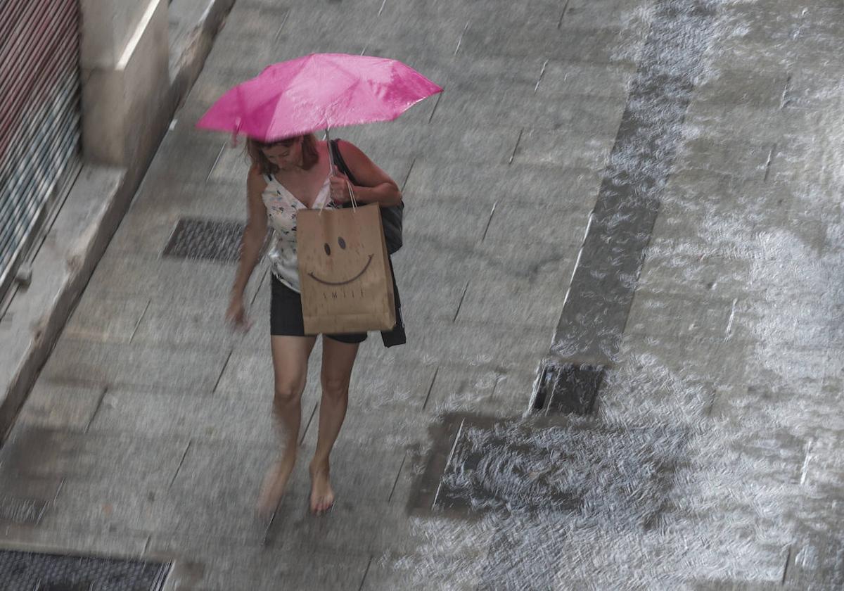 Una mujer se refugia de la lluvia en una imagen de archivo.