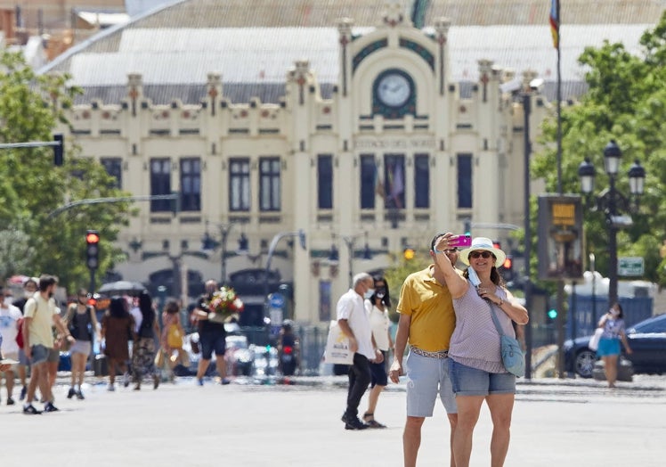 Dos turistas se hacen un selfie en la plaza del Ayuntamiento.