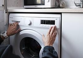 Una persona enchufa la lavadora en una imagen de archivo.