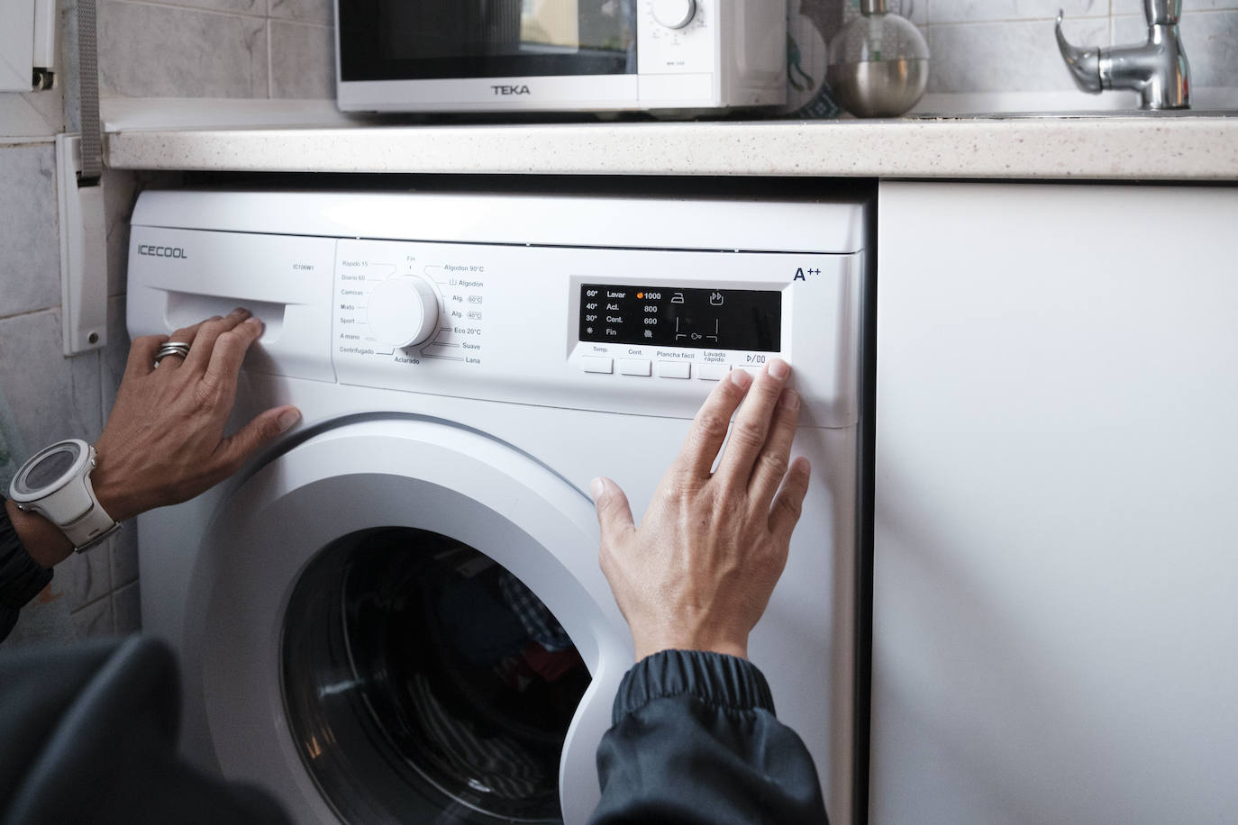 Una persona enchufa la lavadora en una imagen de archivo.