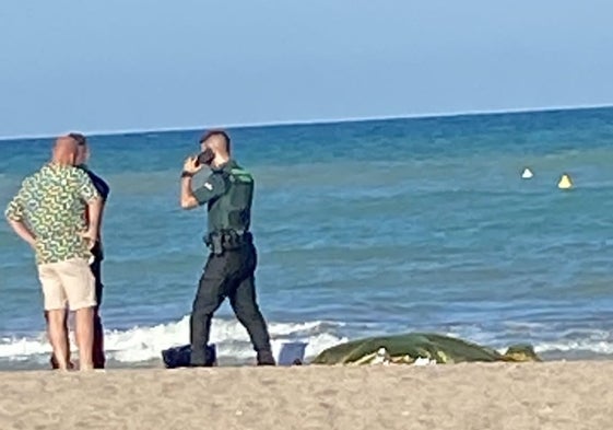 Dos guardias civiles junto al cadáver del bañista.