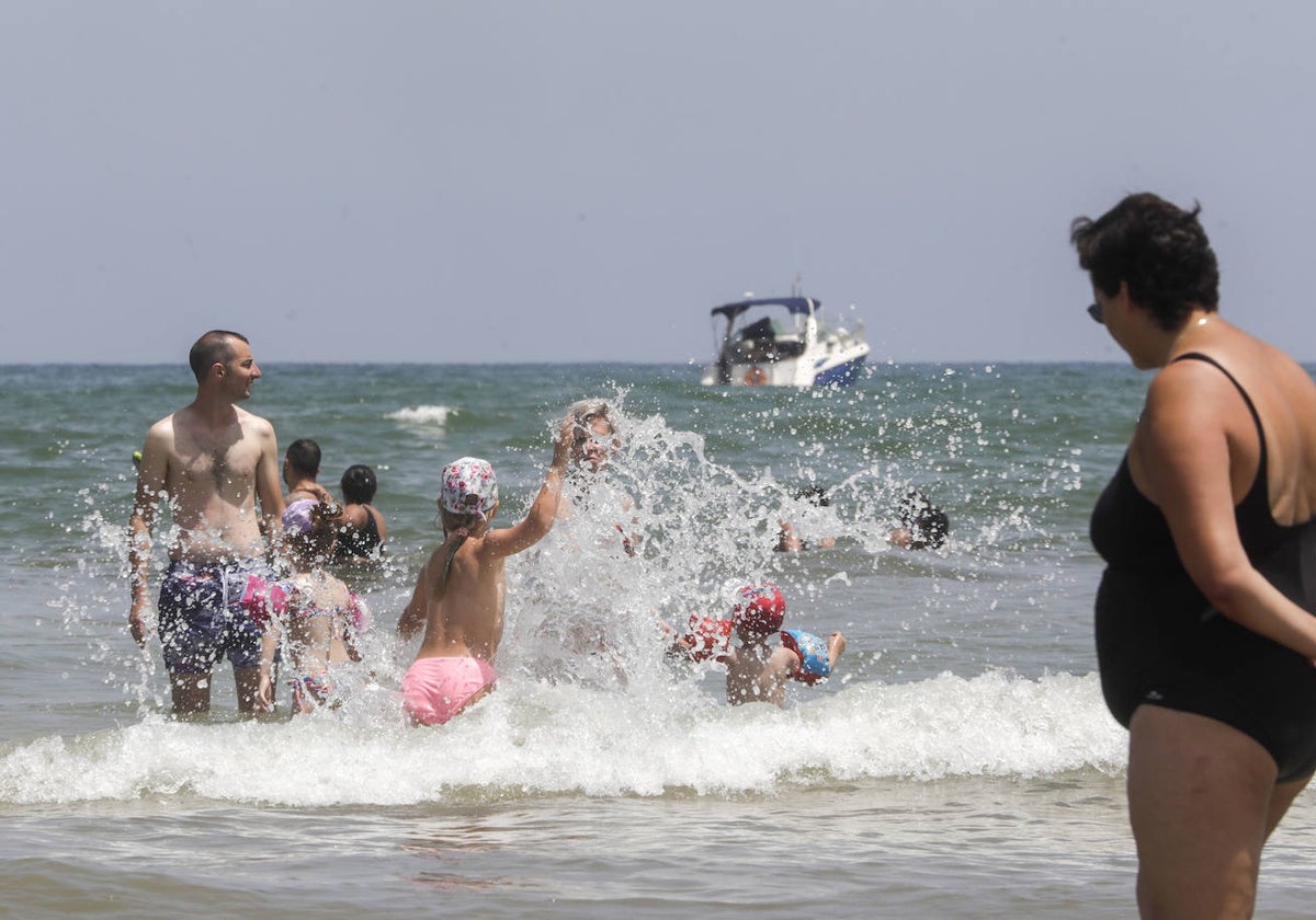 Una familia se da un baño en el mar para vencer el calor que asoló ayer en Valencia.