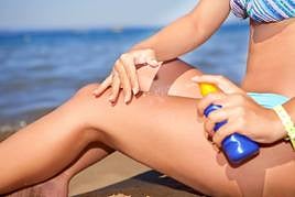 Una mujer protege su piel con crema solar.