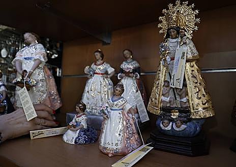 Imagen secundaria 1 - Artículos. En las estanterías destacan abanicos, llaveros, imanes, monederos y tazas. 