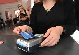 Una mujer pagando con tarjeta en una imagen de archivo.
