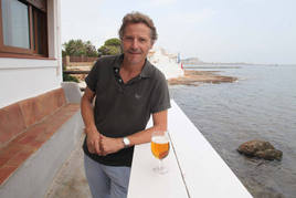 David Escolá, con una cerveza en la terraza del Helios, uno de los locales ubicados en Les Rotes.