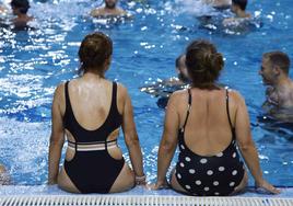 Dos señoras sentadas en el borde de una piscina