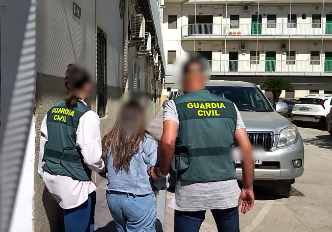 Dos agentes de la Guardia Civil trasladan a una de la detenidas.