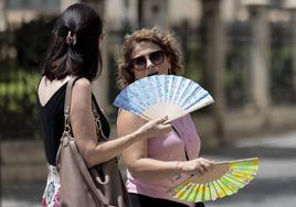 Dos personas combaten con un abanico el calor de estos días en Valencia.